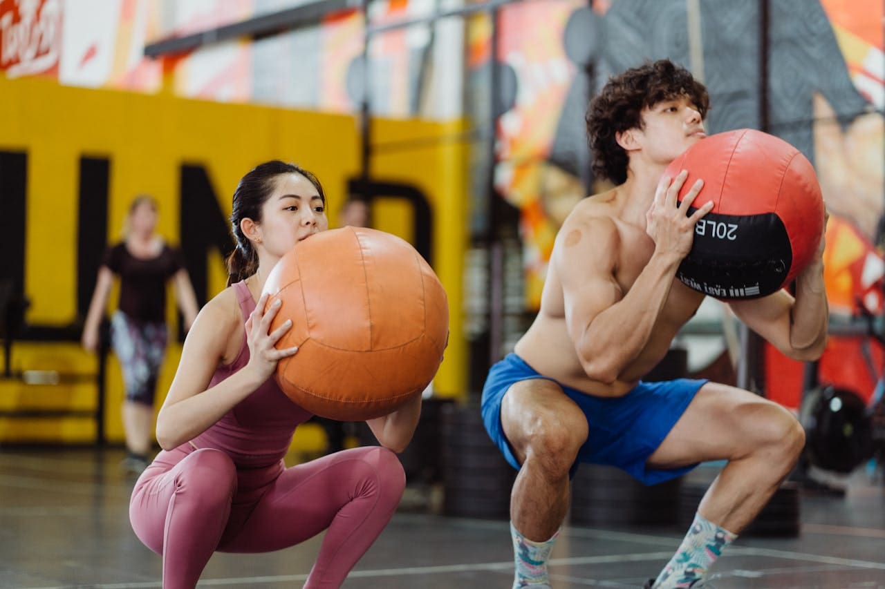 comment maigrir des cuisses :  un binôme fait un squat avec un ballon